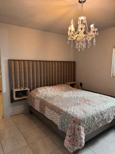 a bedroom with a bed and a chandelier at Estancias Nava #2 in San Antonio