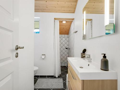 a bathroom with a white sink and a toilet at Holiday Home Aleth - 800m from the sea by Interhome in Gedesby