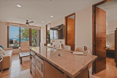 a kitchen with a large island and a living room at Chill in the tropics with style in Sayulita