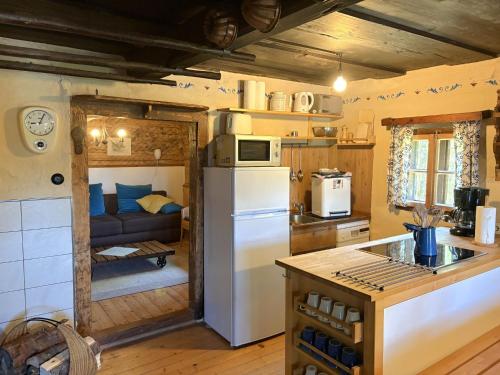 a kitchen with a refrigerator and a couch in a room at Chalet Schipplbadstube by Interhome in Annaberg im Lammertal