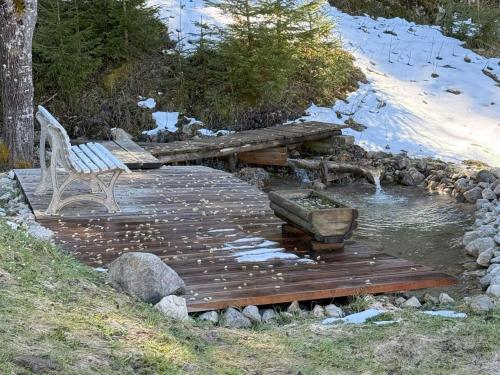 a wooden deck with a bench and a water fountain at Chalet Schipplbadstube by Interhome in Annaberg im Lammertal