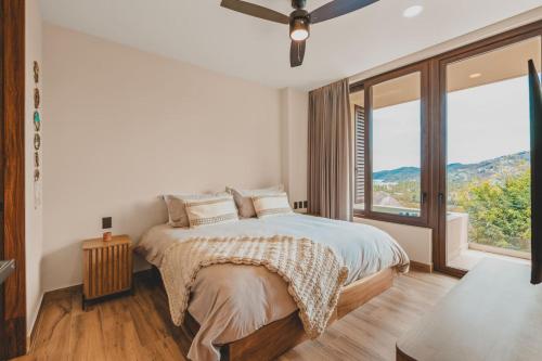 a bedroom with a bed and a large window at Designer Penthouse with Plunge Pool in Sayulita