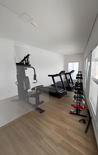 a gym with several tread machines in a room at Apartamento inteiro com vaga, varanda e piscina in Cotia