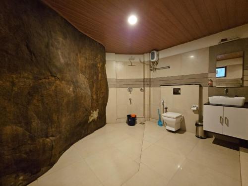 Un baño con lavabo e inodoro. en Edakkal Village Resort - A Premium Boutique Lodging, Wayanad, en Ambalavayal