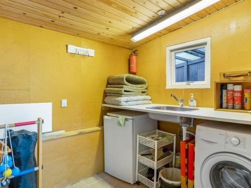 a laundry room with a sink and a washing machine at Holiday Home Teodosija - 20m from the sea by Interhome in Skelde