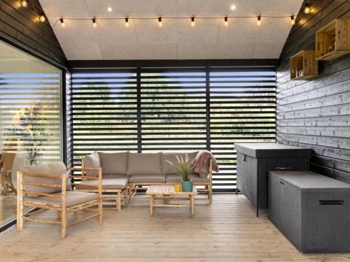 a living room with a couch and a table and chairs at Holiday Home Sigrun - 300m from the sea by Interhome in Kelstrup Strand