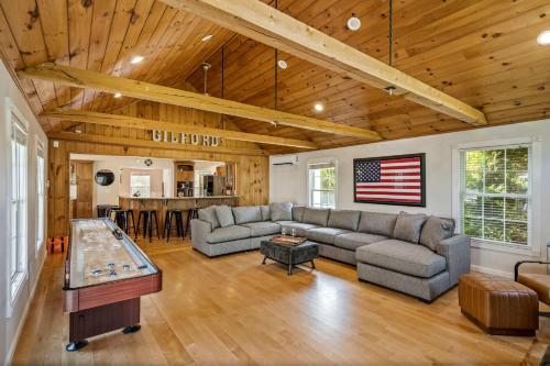 a large living room with an american flag on the wall at Gilford Getaway - Pool & Hot Tub - Lakes Region in Gilford