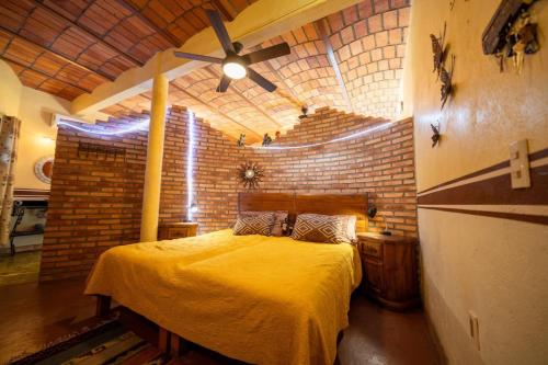 ein Schlafzimmer mit einem gelben Bett mit Ziegelwand in der Unterkunft Casa Happy Sol - Delfin - Pool Boho Beach Vibes in San Francisco