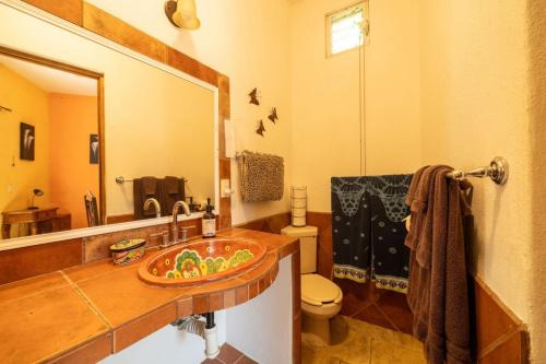 ein Badezimmer mit Waschbecken, Toilette und Spiegel in der Unterkunft Casa Happy Sol Atun Balcony Pool Beach Vibes in San Francisco