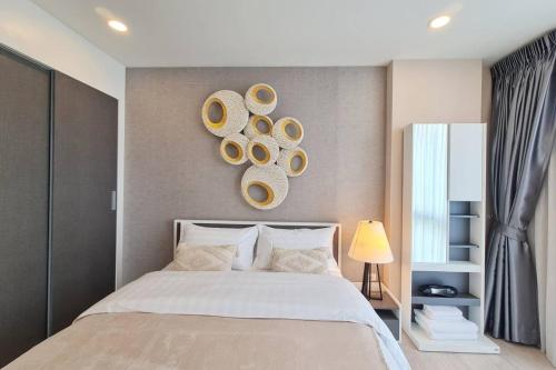 a bedroom with a bed with a clock on the wall at Cozy Condo Perfect Location In Nimmanhemin Maya in Chiang Mai