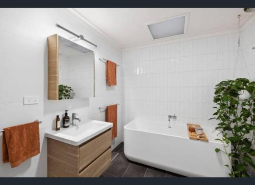 Un baño con bañera blanca y lavabo. en Barnett Bush Retreat, en Torquay