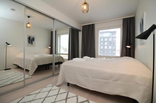 a bedroom with a large bed and a mirror at Spacious Apartment for 2 with Sauna in V in Iso-Heikkilä