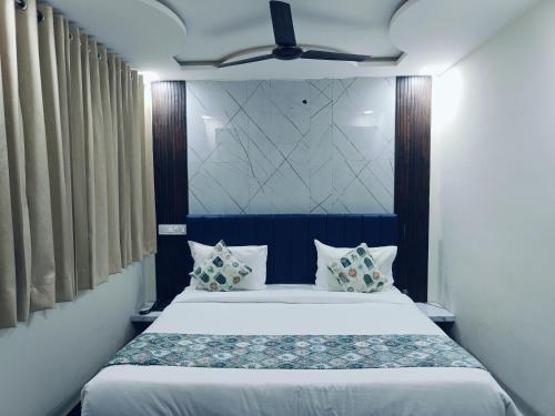 a bedroom with a large white bed with pillows at Hotel jmm s14 in Udaipur