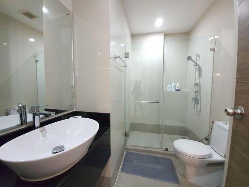 een badkamer met een wastafel, een toilet en een douche bij Live in Nimman High Floor And Rooftop Pool in Chiang Mai