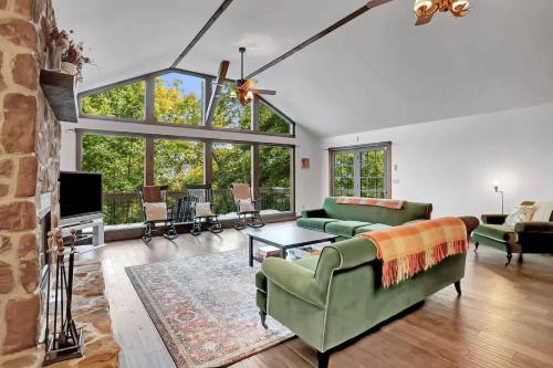 a living room with a green couch and a fireplace at 5 Bedroom Suites Hot Tub Jacuzzi Tub & Game Room in Berkeley Springs