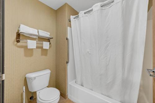 a bathroom with a white shower curtain and a toilet at Colfax Inn By Marifah in Colfax