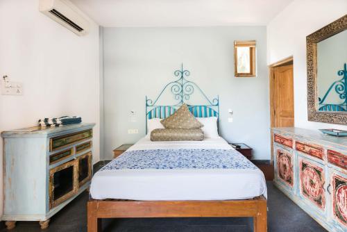 a bedroom with a blue and white bed and a dresser at Casa Da Praia in Candolim