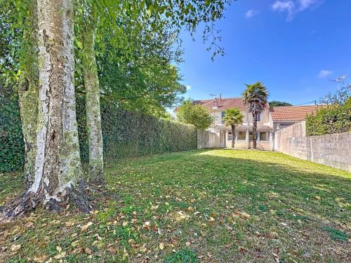 Un patio con una cerca y un árbol y una casa. en Holiday Home Les Vents Doux by Interhome, en Tharon-Plage