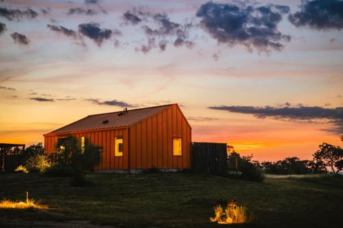 a small red house with a sunset in the background at The Martinsburg in Stonewall