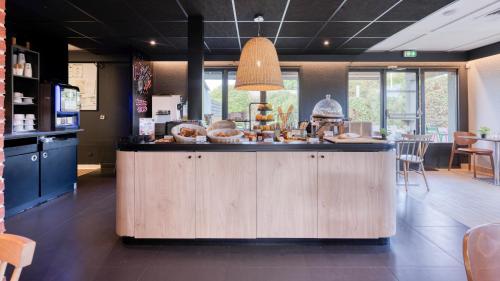 a kitchen with a counter with food on it at Campanile NATURE - Bordeaux Sud Gradignan Talence in Gradignan