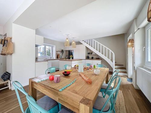 eine Küche und ein Esszimmer mit einem Holztisch und Stühlen in der Unterkunft Holiday Home La Nero by Interhome in Pornic