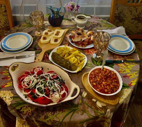 a table with plates of food and bowls of food at Vashlovani Sweet Home in Dedoplis Tskaro