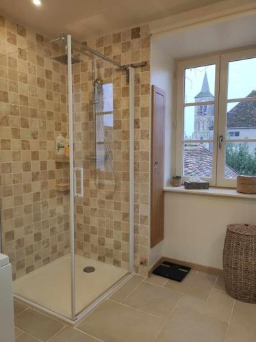 a shower with a glass door in a bathroom at La maison du Boulanger in Pontaubert