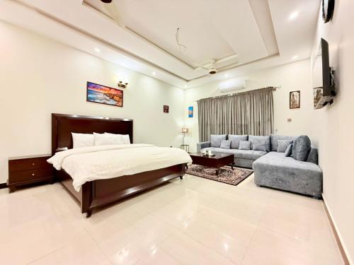 a bedroom with a bed and a couch at Comfort Family Lodges in Islamabad