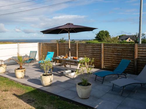 un patio con tavolo, sedie e ombrellone di Holiday Home Entre Terre et Mer by Interhome a Kervasdou