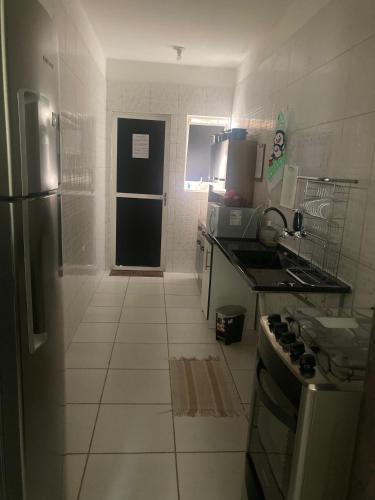 a small kitchen with a refrigerator and a stove at Economize e aproveite a região ou descanse para o voo - 24h in Maceió