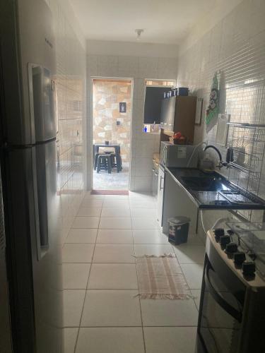 a kitchen with a refrigerator and a tile floor at Economize e aproveite a região ou descanse para o voo - 24h in Maceió