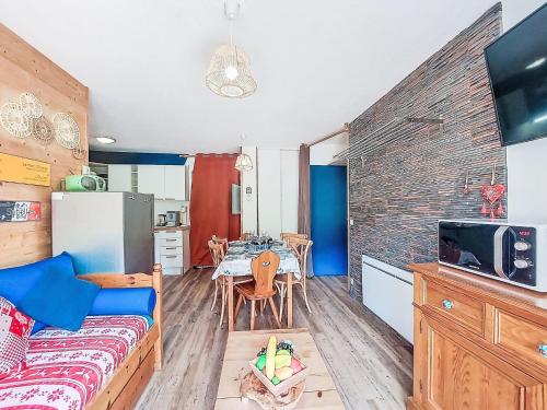 ein Wohnzimmer mit einem Sofa und eine Küche mit einem Tisch in der Unterkunft Apartment Les Pistes-21 by Interhome in Le Corbier