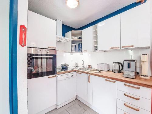 eine weiße Küche mit weißen Schränken und Geräten in der Unterkunft Apartment Les Pistes-21 by Interhome in Le Corbier