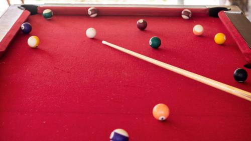 a red pool table with cue sticks and balls at Lake Bogoria Spa Resort in Marigat