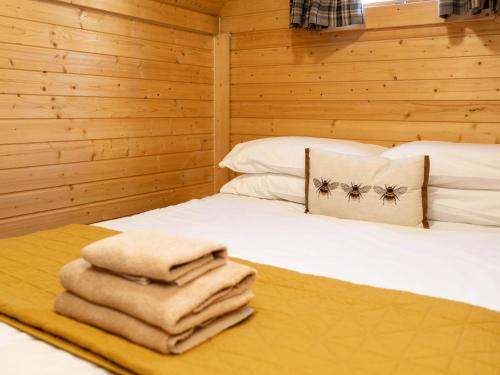 a bedroom with a bed with towels on it at Apartment Birch Bothy by Interhome in Coldstone