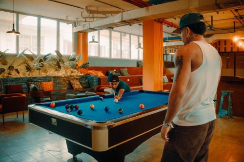 two men standing around a pool table at Viajero Casco Viejo Hostel in Panama City