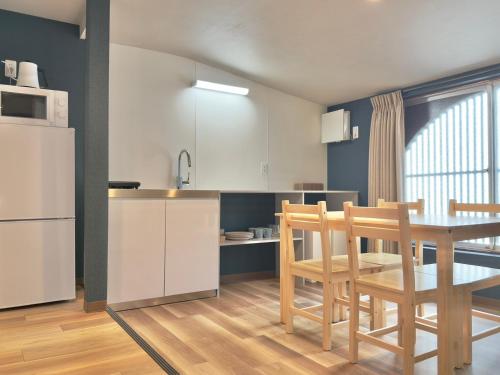a kitchen and dining room with a table and a refrigerator at Hotel Kototoi Juku HAKU in Tokyo