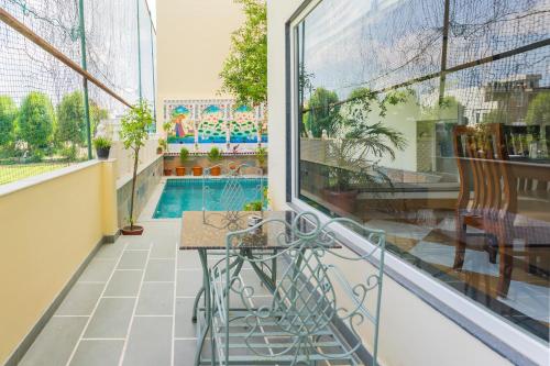 a balcony with a table and a swimming pool at Vasant Vilas in Udaipur