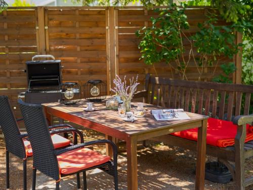 a wooden table and chairs in a yard with a fence at Holiday Home Clarissa by Interhome in Balatonakali