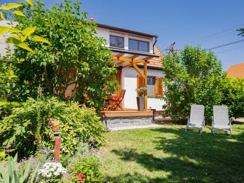 a house with two lawn chairs in the yard at Holiday Home Clarissa by Interhome in Balatonakali