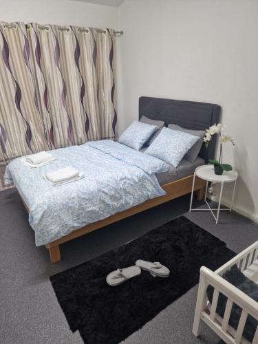 a bedroom with a bed and a pair of slippers at Hafnargata 44 Keflavík 230 in Keflavík