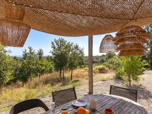 an outdoor table with chairs and an umbrella at Holiday Home Casa Murato by Interhome in San-Giuliano