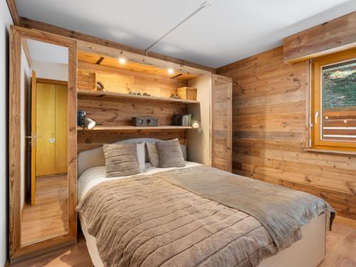 a bedroom with a bed in a room with wooden walls at Apartment Rochemont B26 by Interhome in Icogne