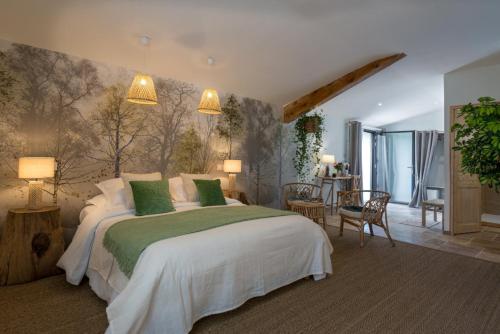 a bedroom with a large bed with green pillows at La Ferme De Mon Grand-père in Saint-Pons