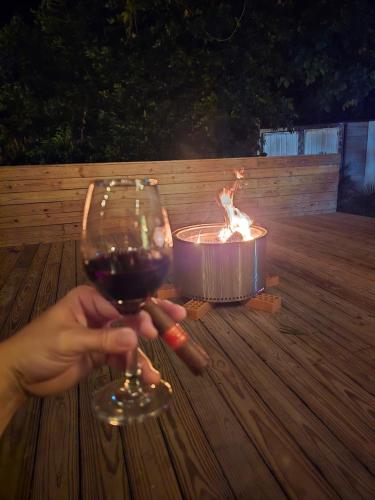 a person holding a glass of wine next to a candle at Cabaña de lujo en la montaña in Santa Marta