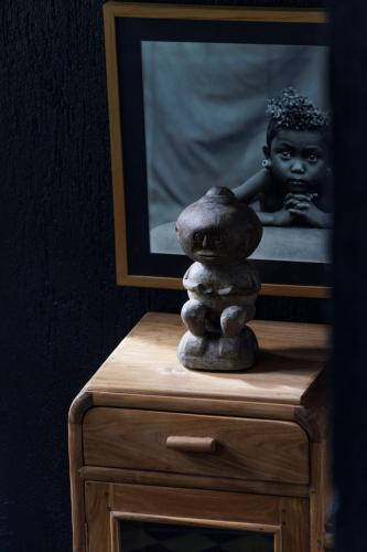 a statue of a boy sitting on a dresser at Sumba Lodge in Manuel Antonio