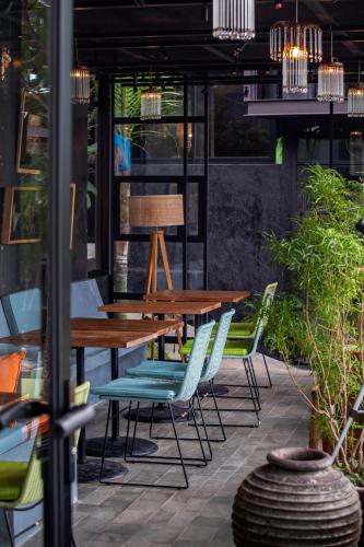 a patio with wooden tables and chairs and plants at Sumba Lodge in Manuel Antonio