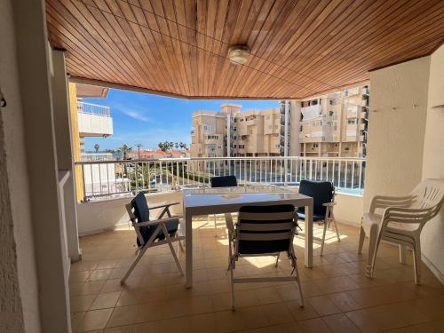 Zimmer mit einem Tisch und Stühlen auf einem Balkon in der Unterkunft Apartamentos Marblau Varios 1, 2 y 3 dormitorios - Julio y Agosto SOLO FAMILIAS in Playa de Gandia
