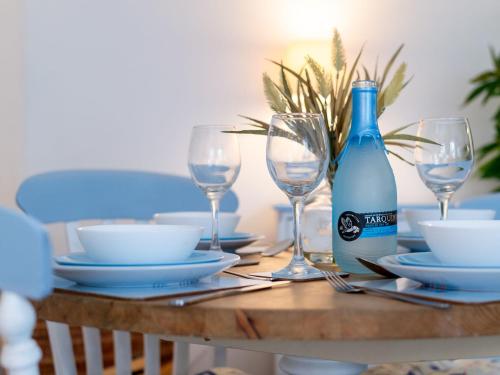a table with glasses and a bottle of wine at Holiday Home Mermaid Cottage by Interhome in Mevagissey