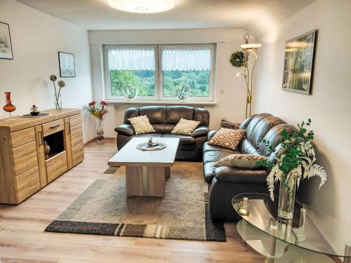 a living room with a leather couch and a table at Apartment Marie by Interhome in Schieder-Schwalenberg